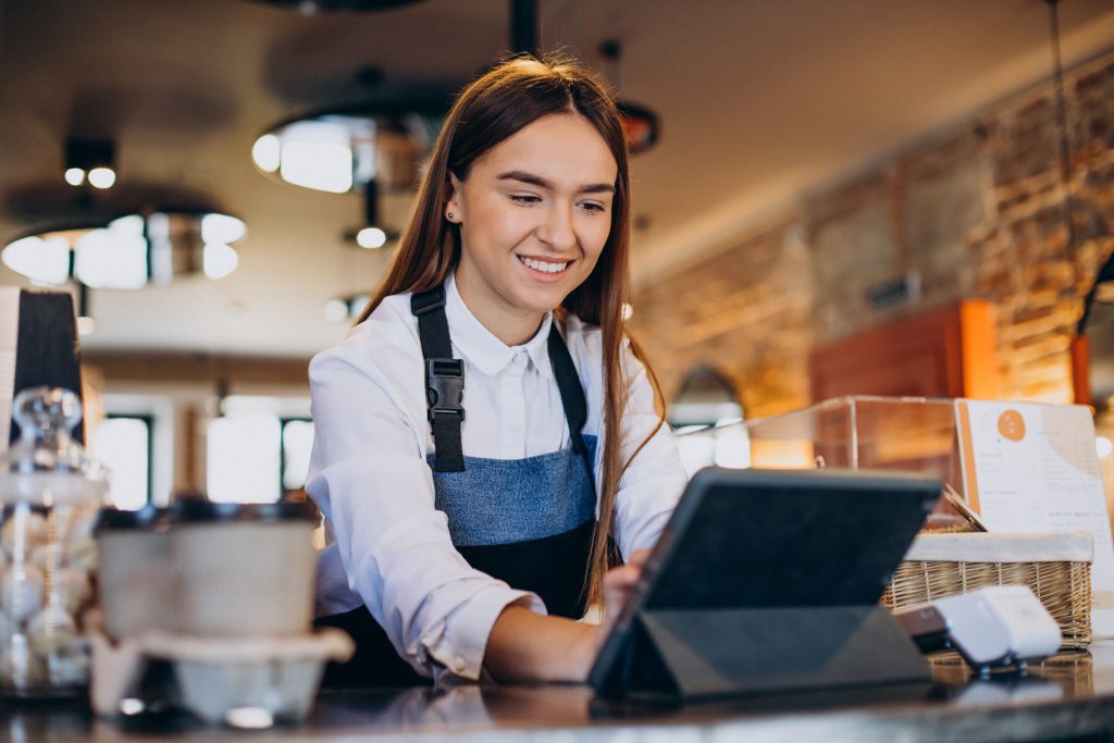 Female barista with tablet making order in a coffee shop